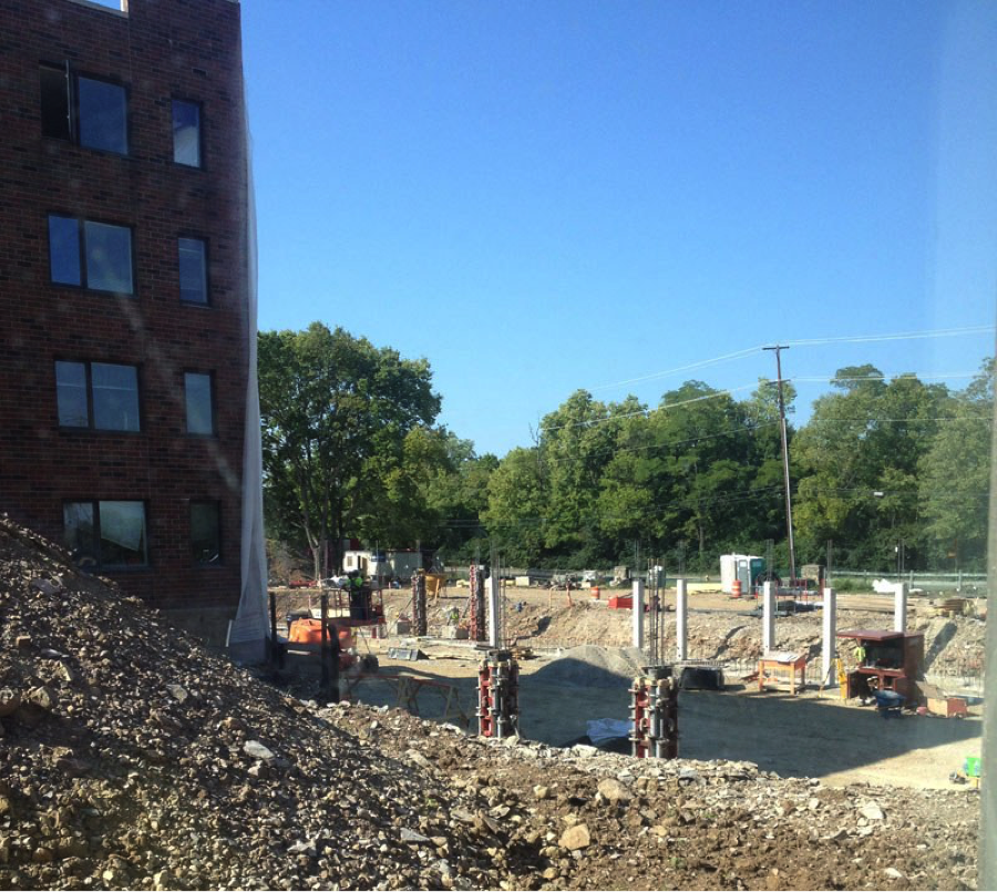 pile of dirt and rocks next to building and poles in the ground