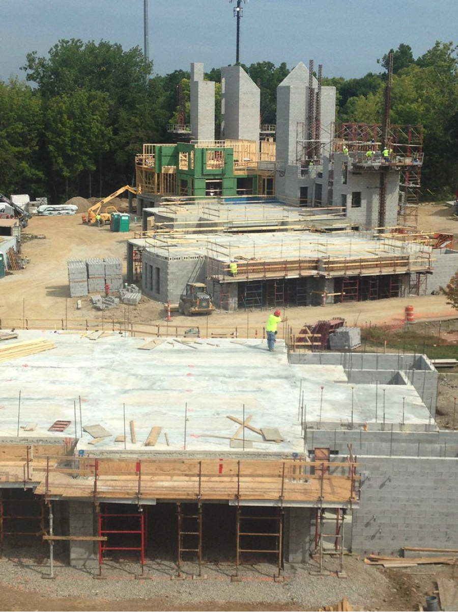 Construction site with partial foundation and workers continue to build buildings