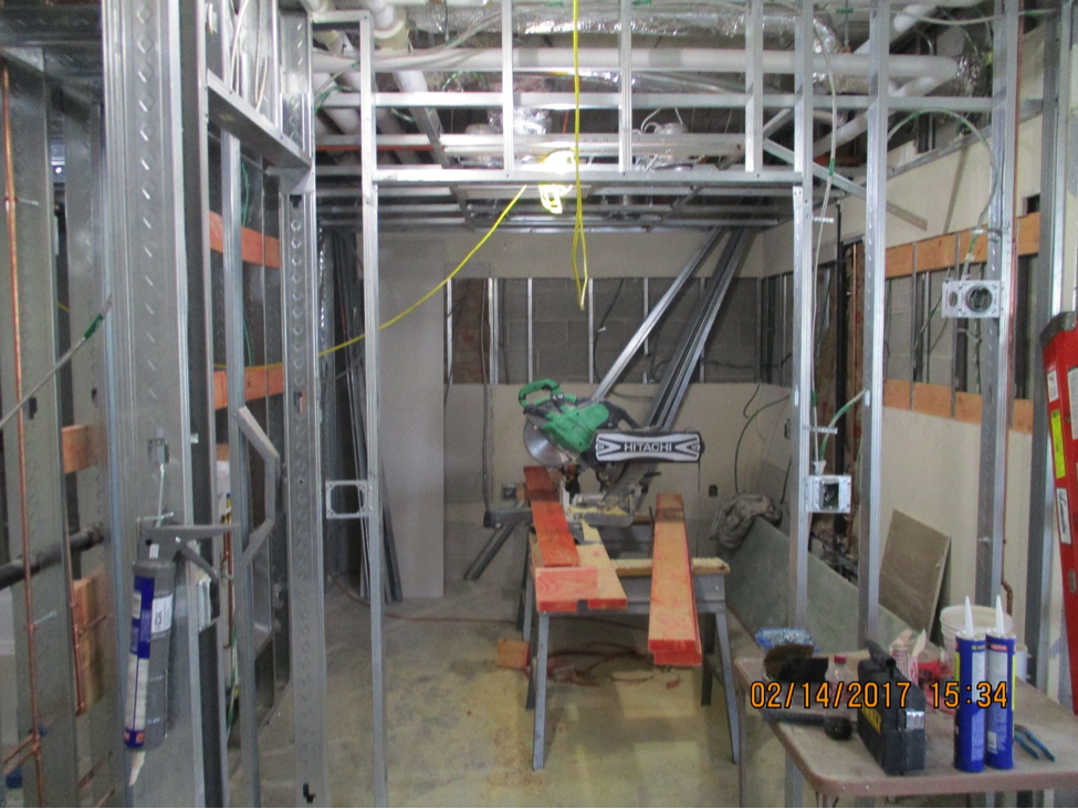 Inside view of room under construction with metal framing and electric saw in the middle of the room
