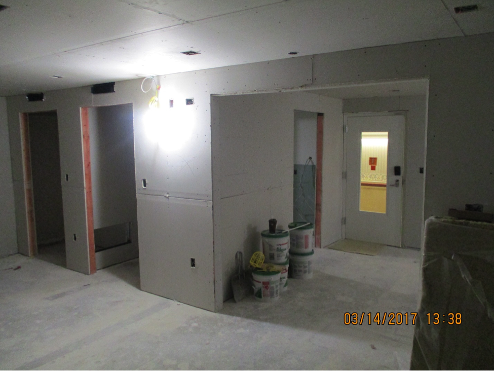 Inside of offices with door cut outs and buckets against wall