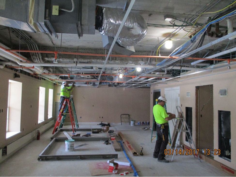 Construction workers hanging ceiling tiles