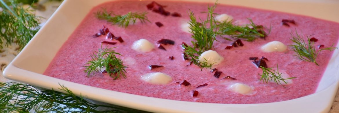 pink soup in a white serving bowl