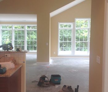 View into room with many windows and construction tools on the ground