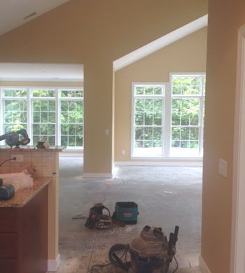 View into room with many windows and construction tools on the ground