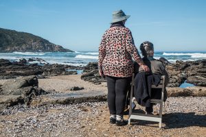 Two women on a rocky beach looking out onto the water