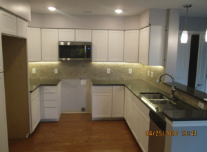View of new kitchen partially done with white cabinets and stainless steel appliances