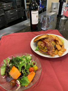 salad and hamburger with home fries with wine