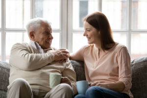 Senio man talking to daughter on the couch