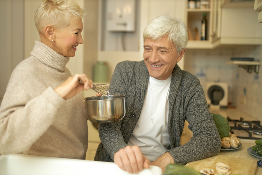 attractive older couple in kitchen talking about senior living options