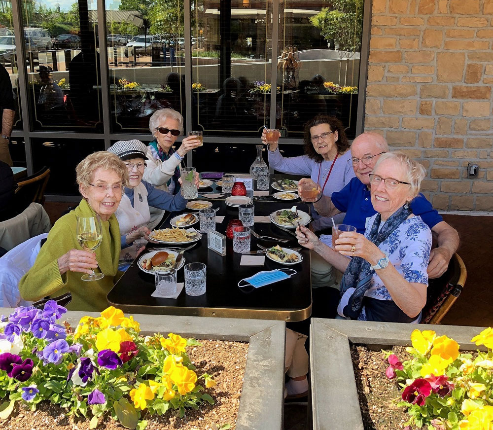 group of happy senior couples raising a toast during dinner