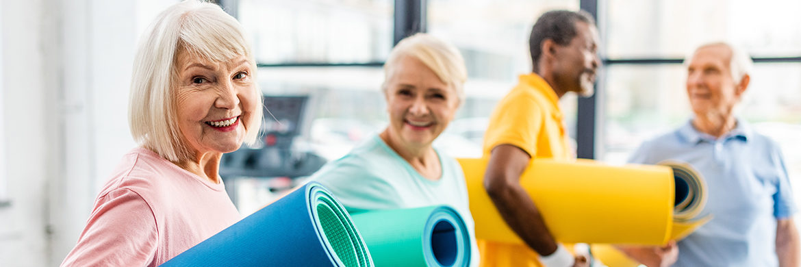 Group of seniors with exercise mats demonstrating physical wellness