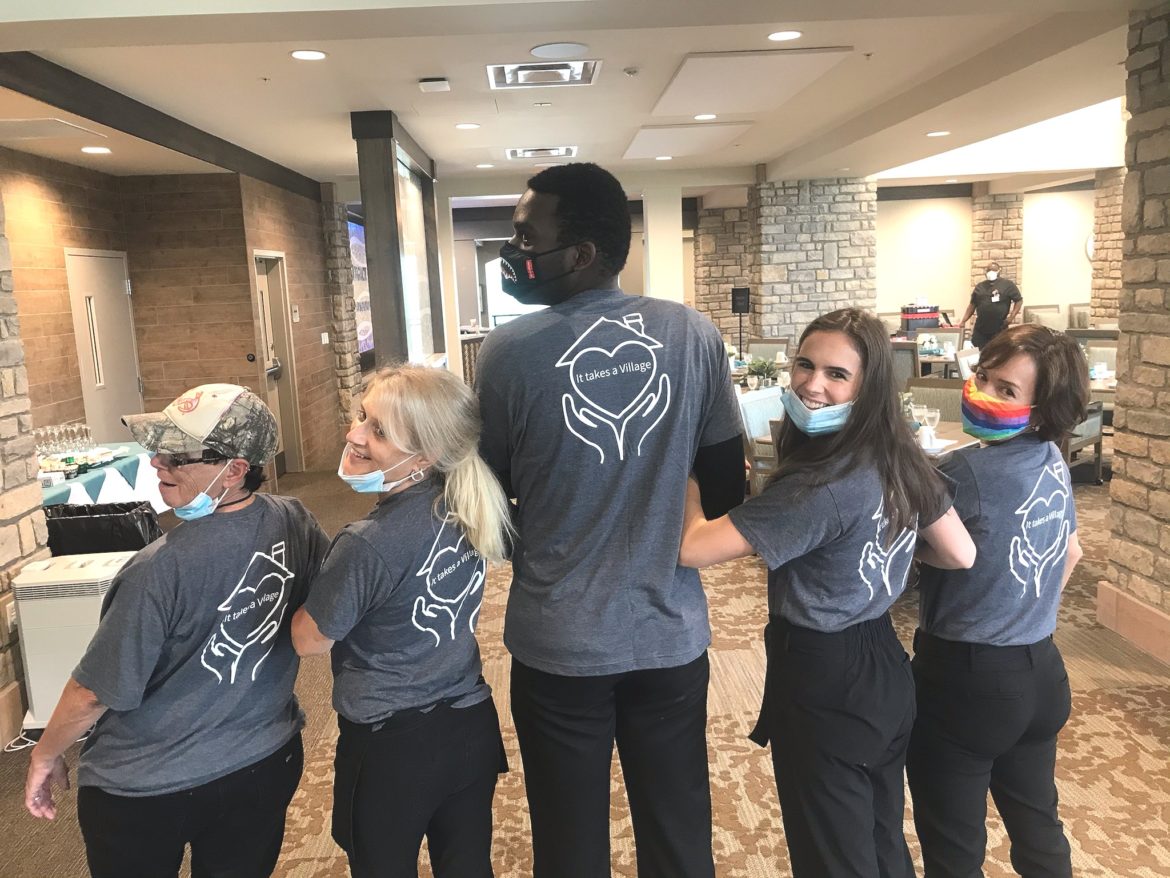 associates wearing It Takes a Village t-shirts