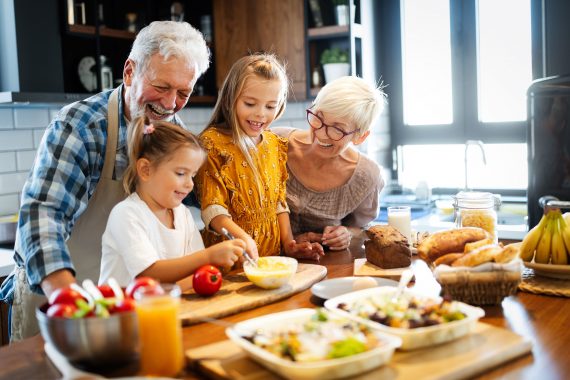Senior couple cooking with grandchildren