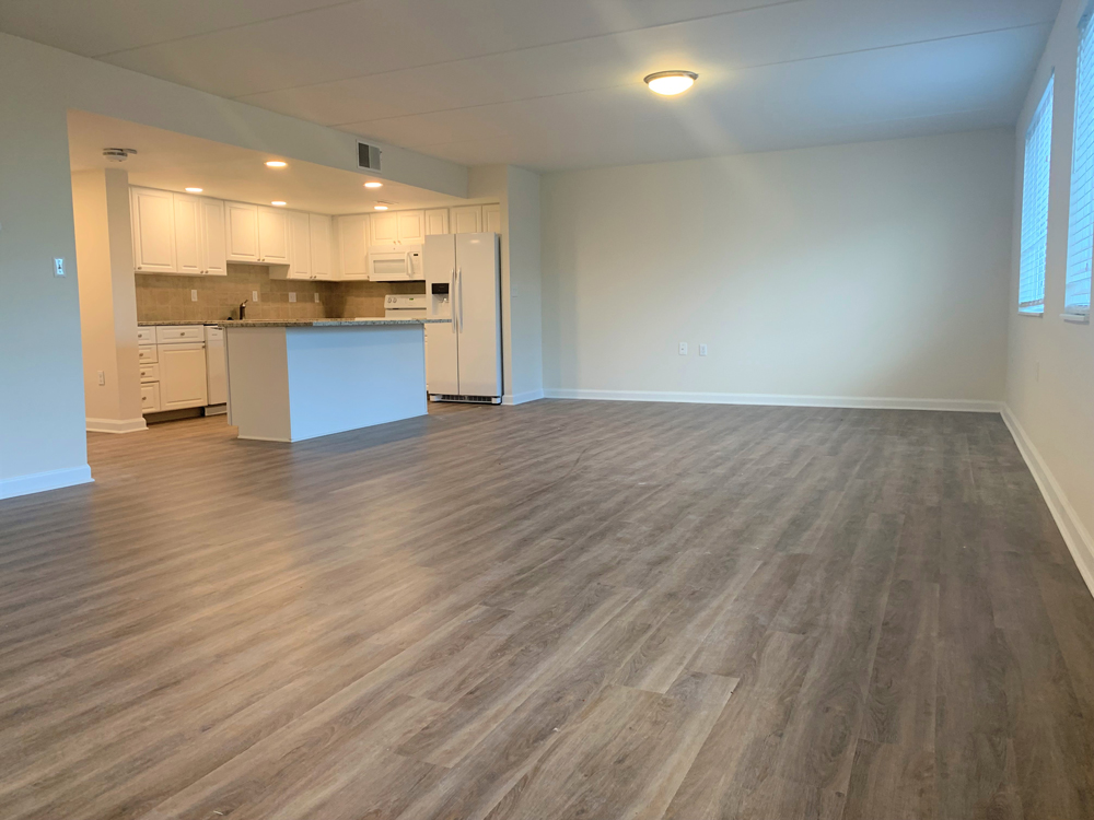 open concept living and dining rooms connect to spacious kitchen in The Quinn II independent living apartment