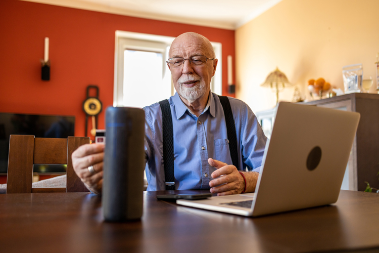 senior man using digital assistant technology to age at home