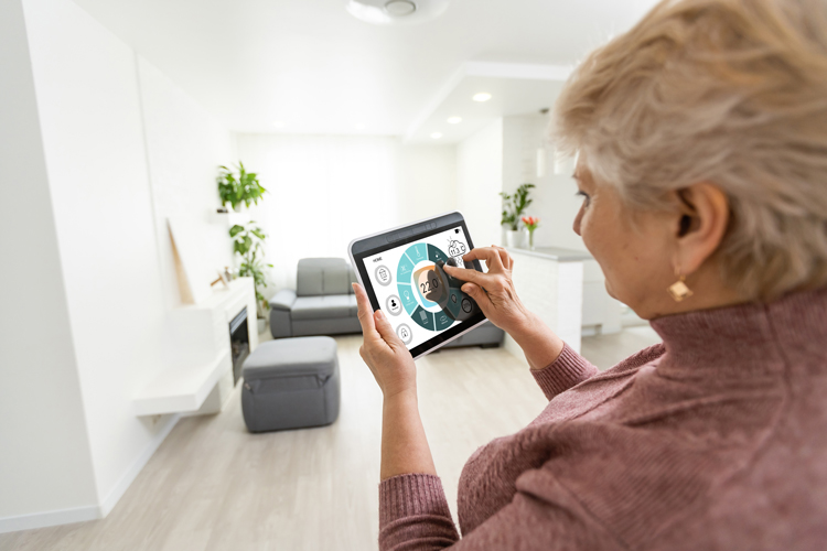 woman with tablet computer using smart home technology for seniors