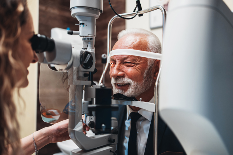 bearded older man receives eye exam