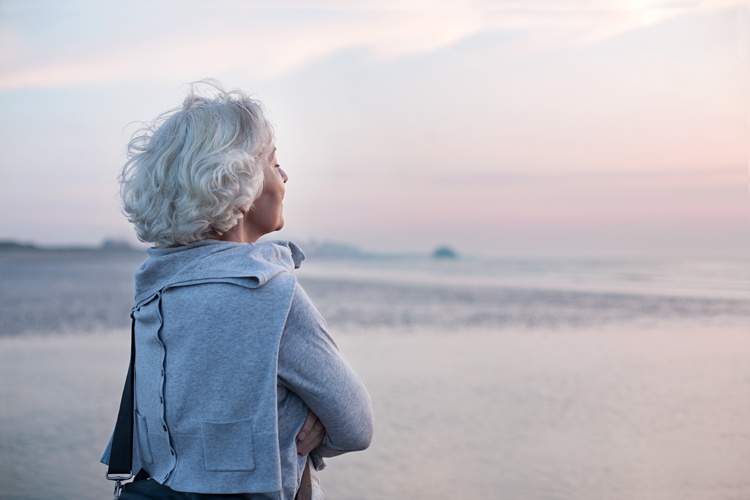 senior woman experiencing wellness on beach