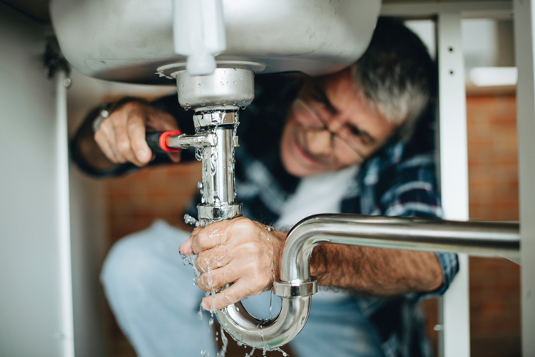 Senior man handling plumbing home maintenance
