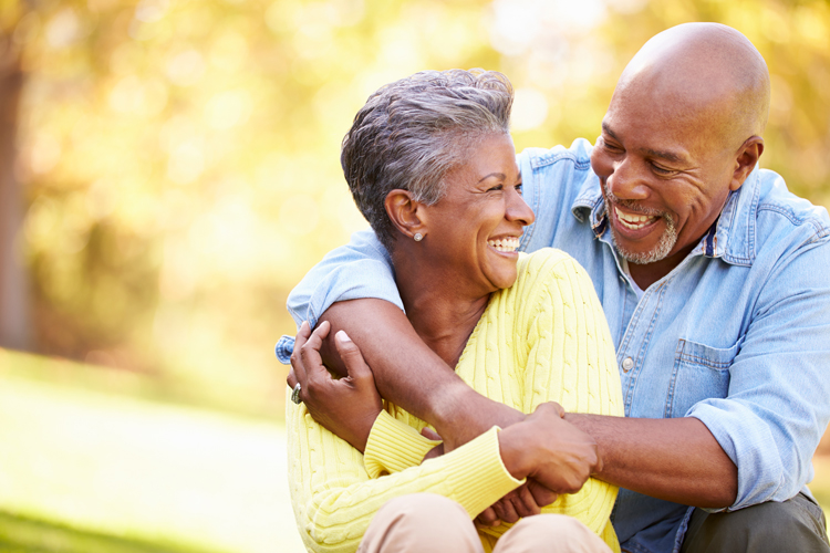 Happy senior couple embracing on park bench.