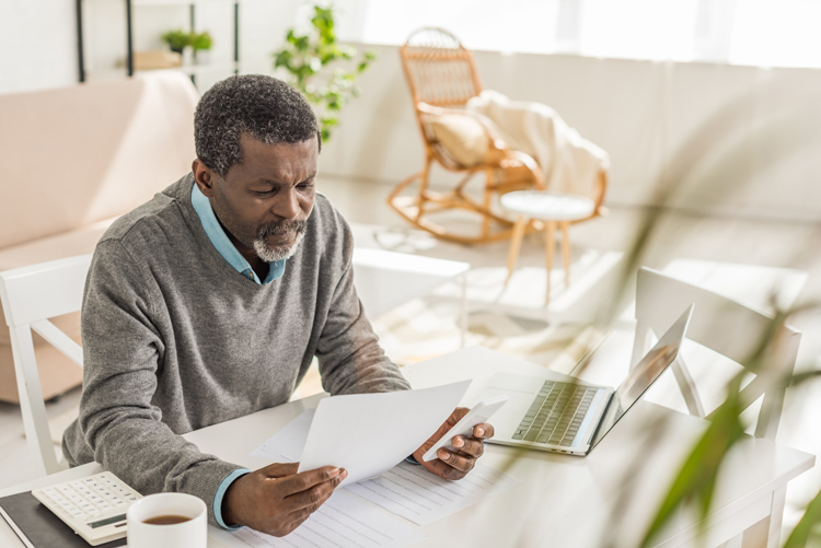Older man creating a budget for aging solo.
