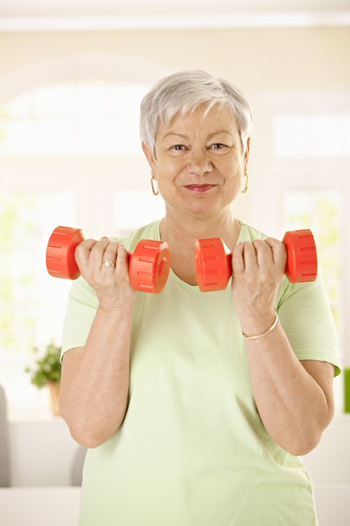 Older woman lifting two orange dumbells