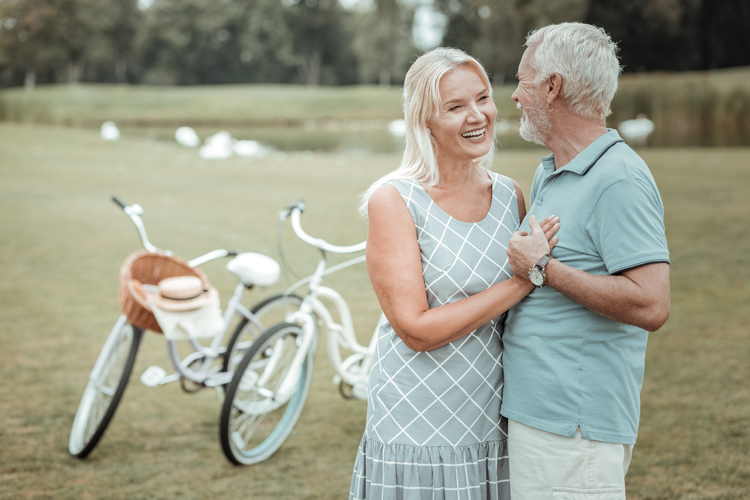 Senior couple embracing with bicycles in the background