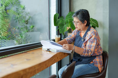 Senior woman reviewing bills.