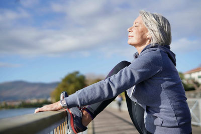 Healthy lifestyle: senior woman stretches before working out