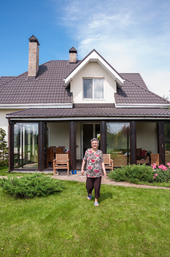 A lovely older woman in front of her private home