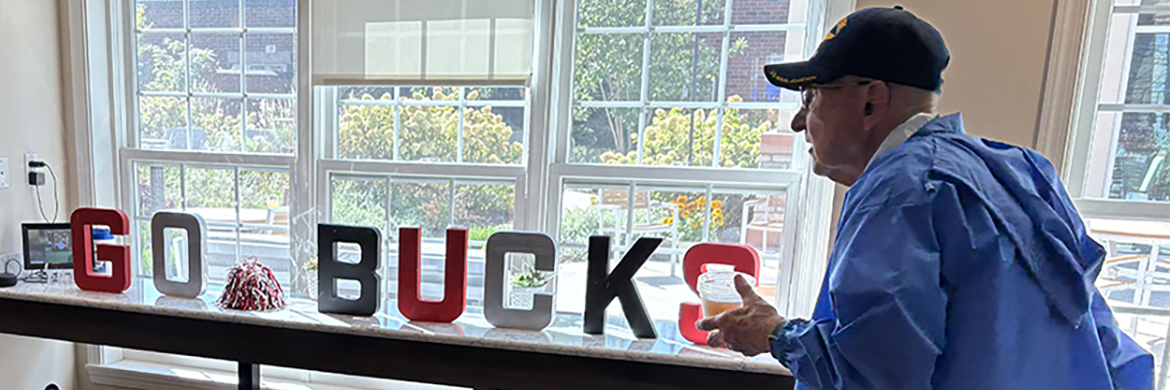Man with Go Bucks sign in window