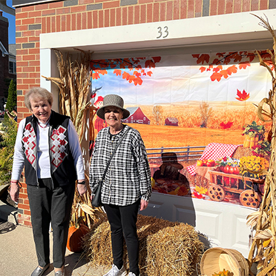 Residents posing in front of fall decorations 