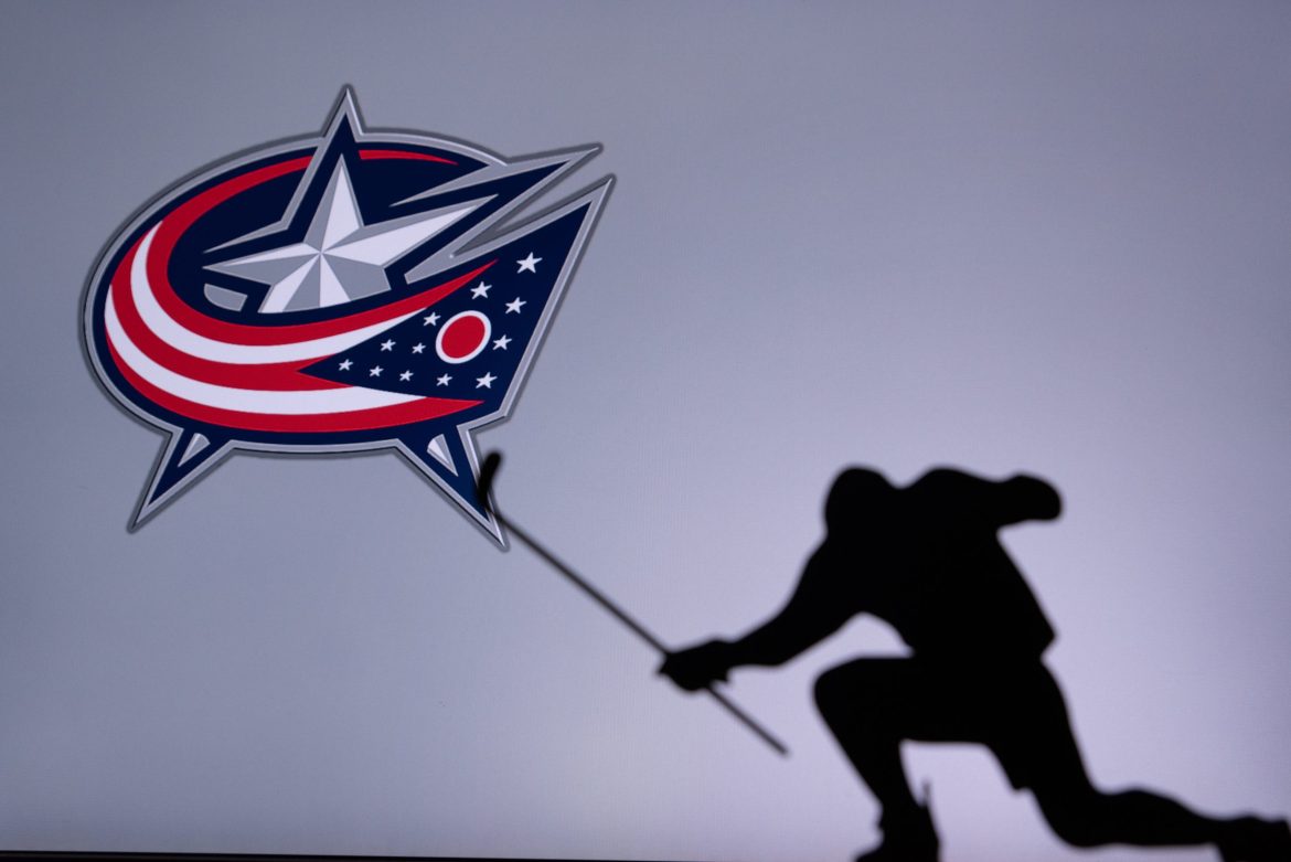 Image of a hockey player with a Columbus Blue Jackets flag.