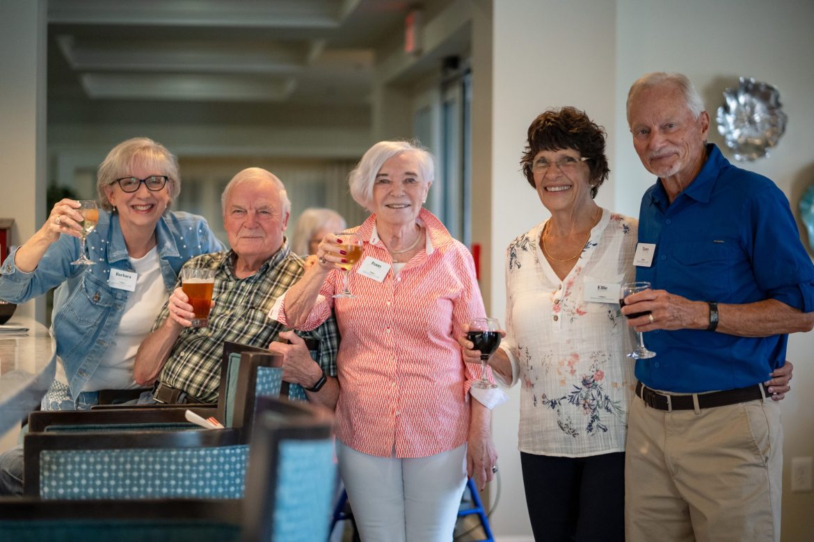 A group of Friendship Village of Dublin Residents raise their glasses in a toast.
