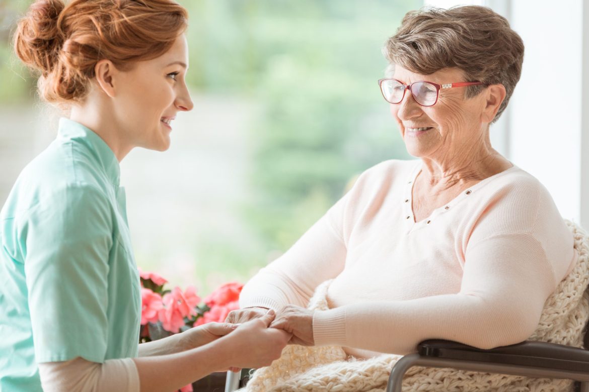 Staff member assisting woman in memory care.