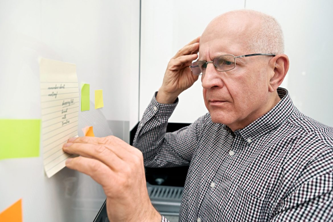 Man with dementia confused by notes on a refrigerator.
