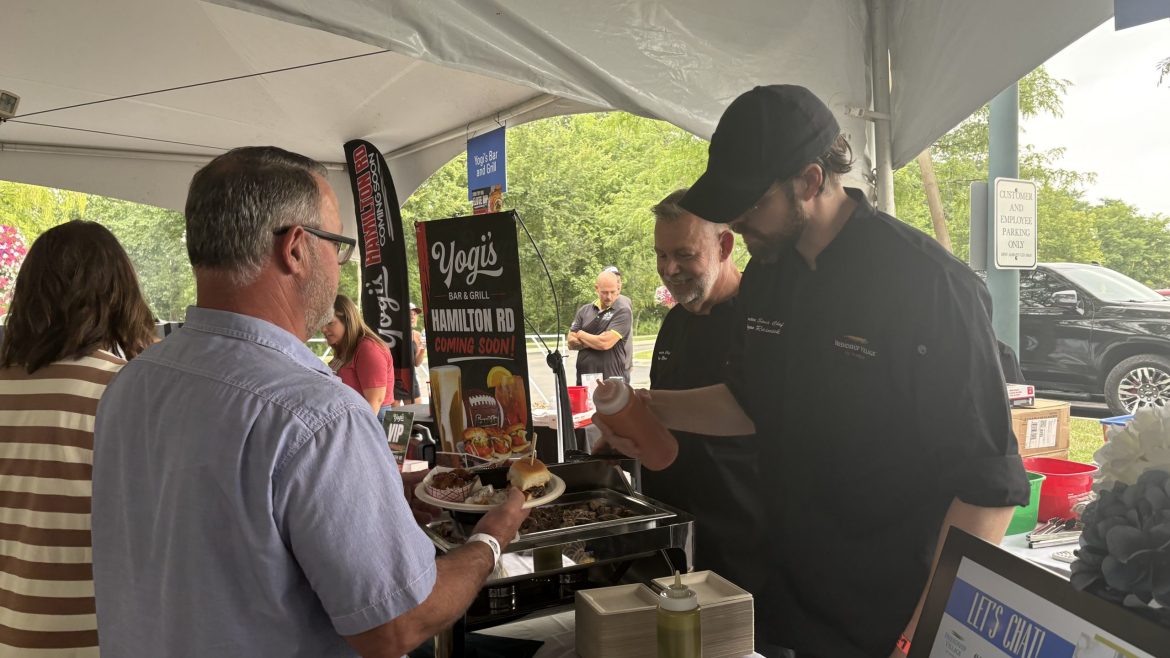 Chef Logan serves the event-winning dish to a judge.
