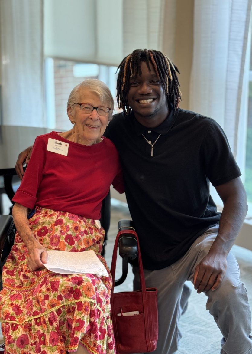 An associate and scholarship honoree (right) kneels to take a photo with an FVD resident and scholarship fund donor.